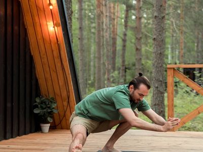 Peaceful outdoor scene with a yoga mat rolled out on a wooden deck.